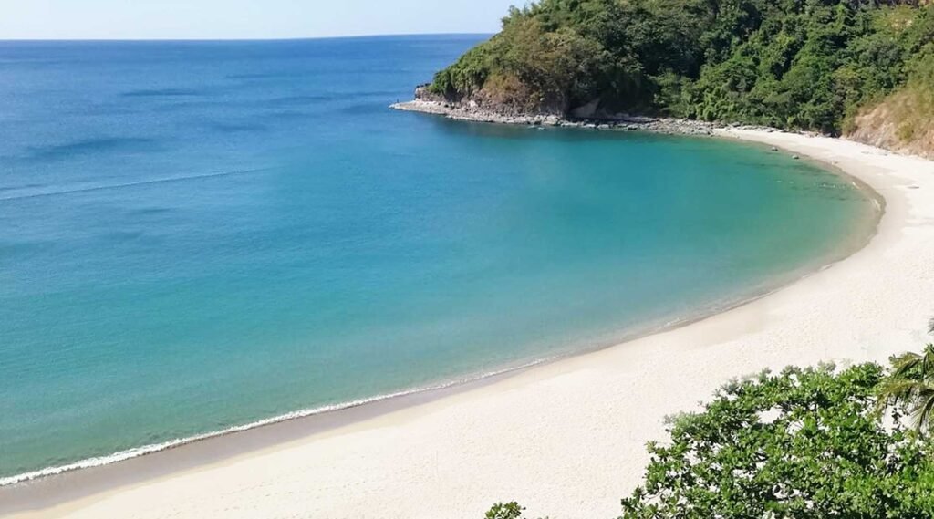 Praia de Lopes Mendes vista de cima, faixa extensa de areia branca e mar azul-turquesa cercado por Mata Atlântica em Ilha Grande